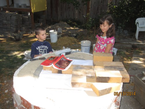 Now that we have the insulation and thermal resevoir in the base it is time to lay out the hearth.  The kids consider geometry.... 