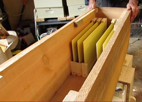 Frames are cut away to be able to see the comb being built through the observation window.